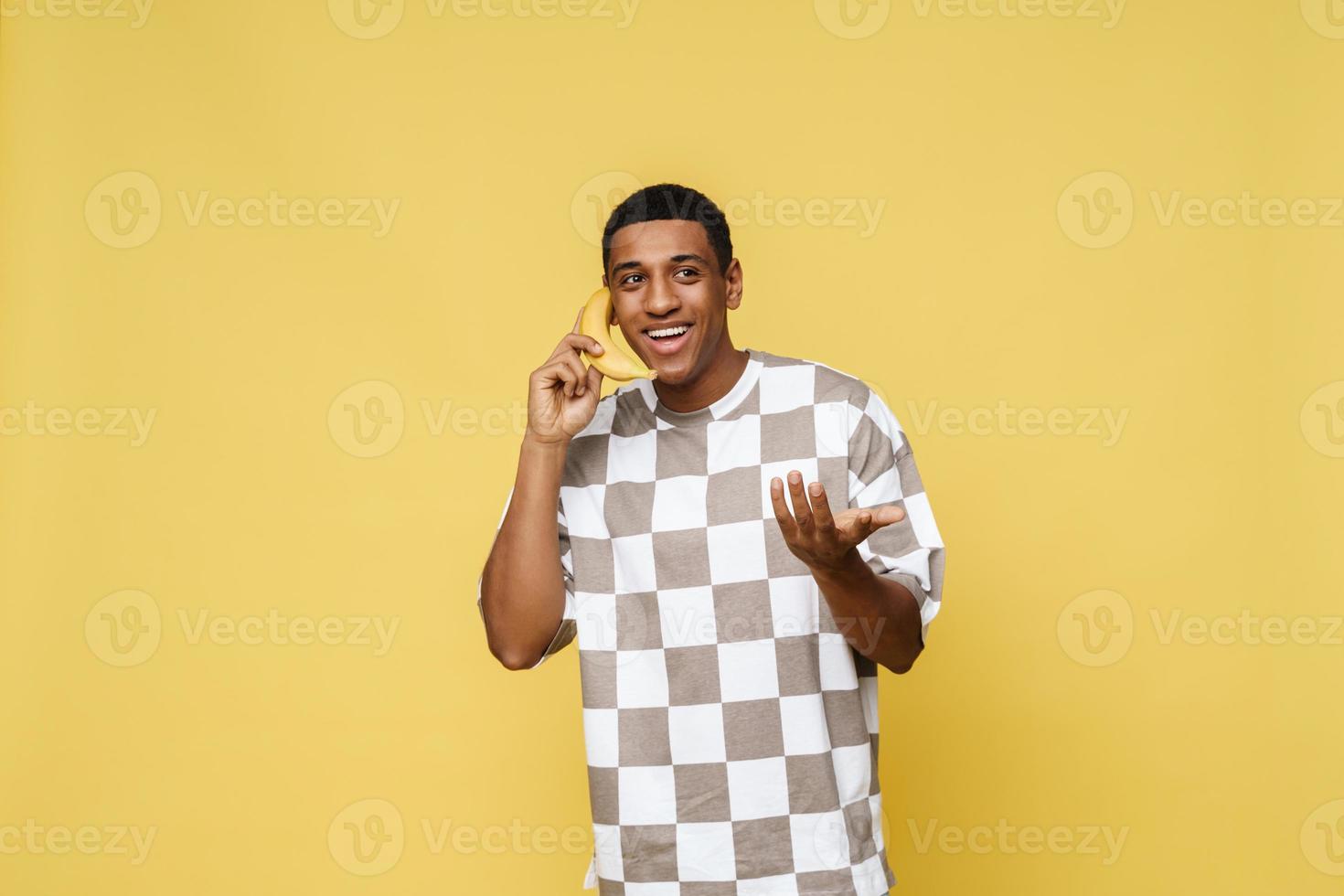 Smiling African man makes a call on banana photo