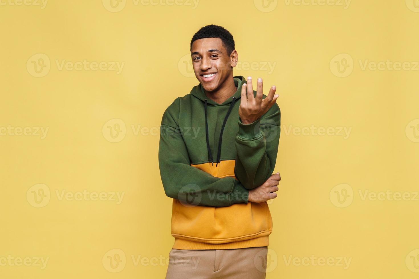 Positive smiling African man in hoodie looking at camera photo
