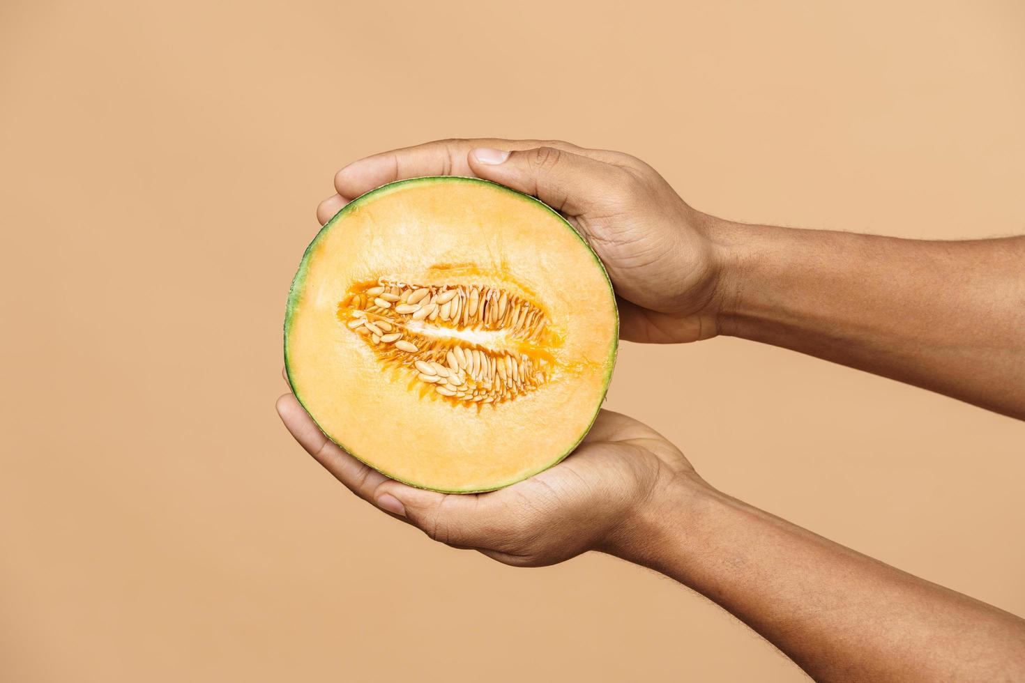 African man holding ripe melon photo