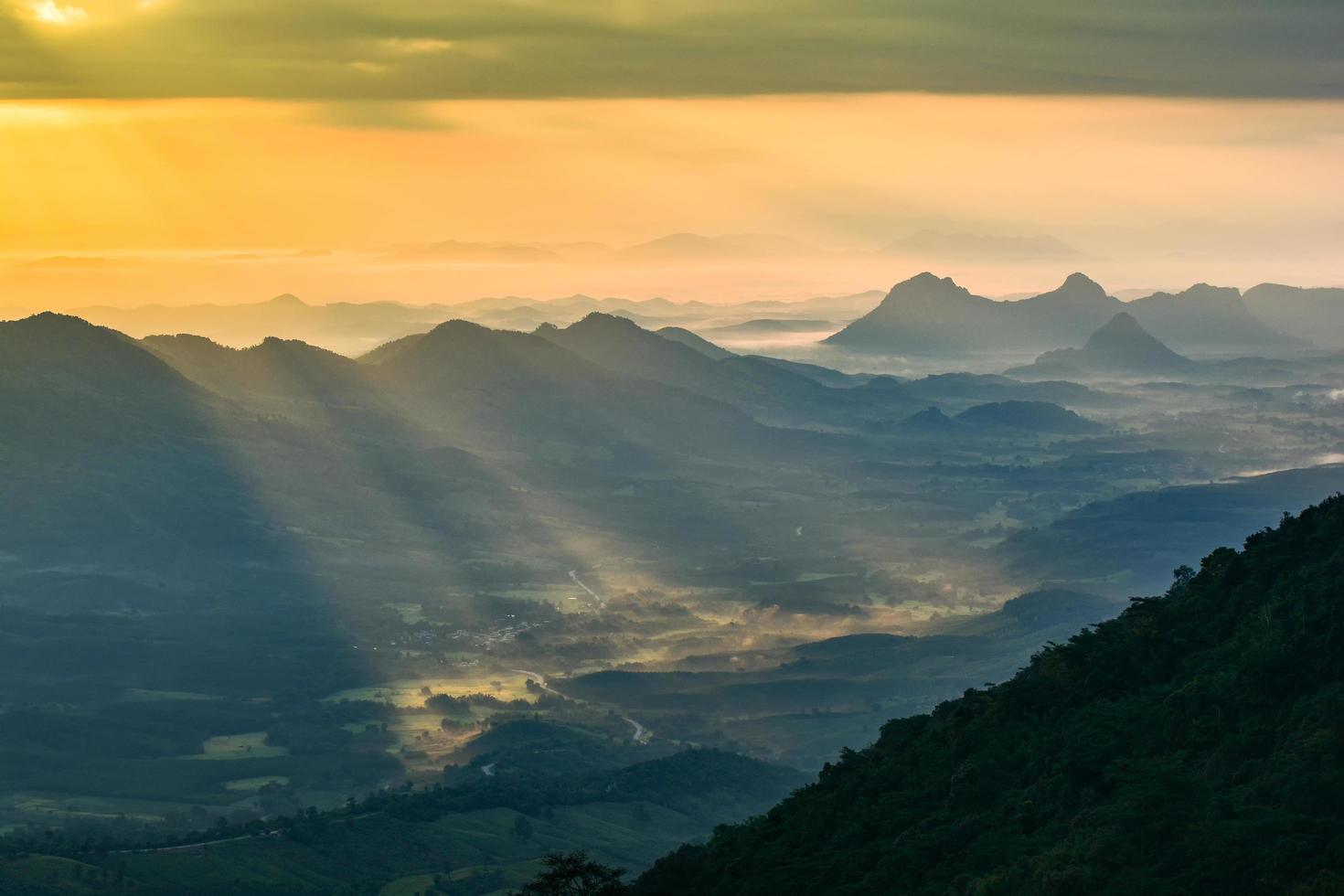 maravilloso paisaje amanecer en la mañana nuevo día en la montaña de la colina con rayos de sol brillando en el cielo de nubes foto