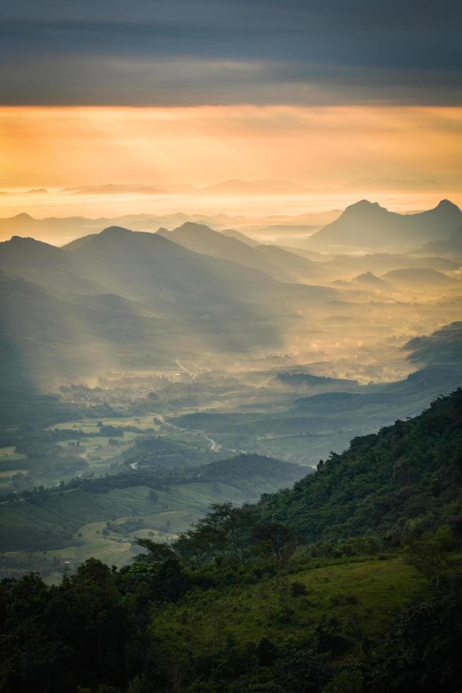 Wonderful sunrise in the morning new day on hill mountain with rays of sunlight shining on the cloud sky photo