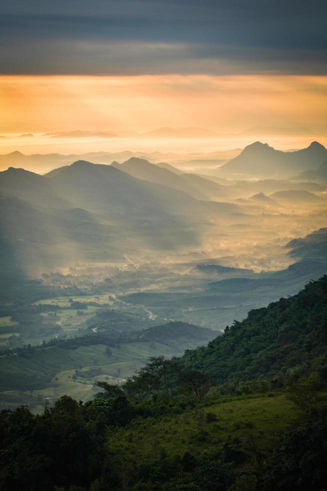 maravilloso amanecer en la mañana nuevo día en la montaña de la colina con rayos de sol brillando en el cielo de nubes foto