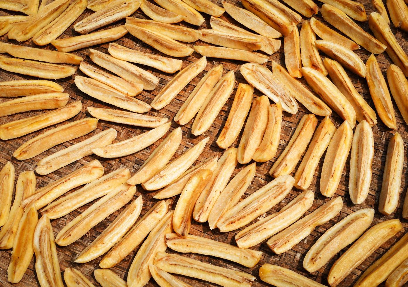 Dried banana background Organic banana long slice dry on bamboo threshing basket for sun drying photo