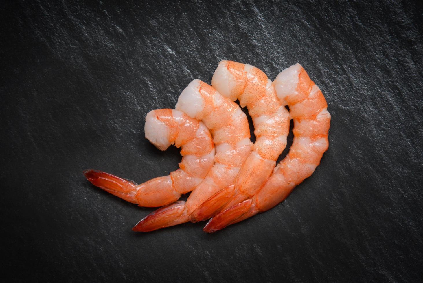 camarones sobre fondo oscuro mariscos mariscos cuatro camarones langostinos hervidos cocinados para comida en la mesa foto