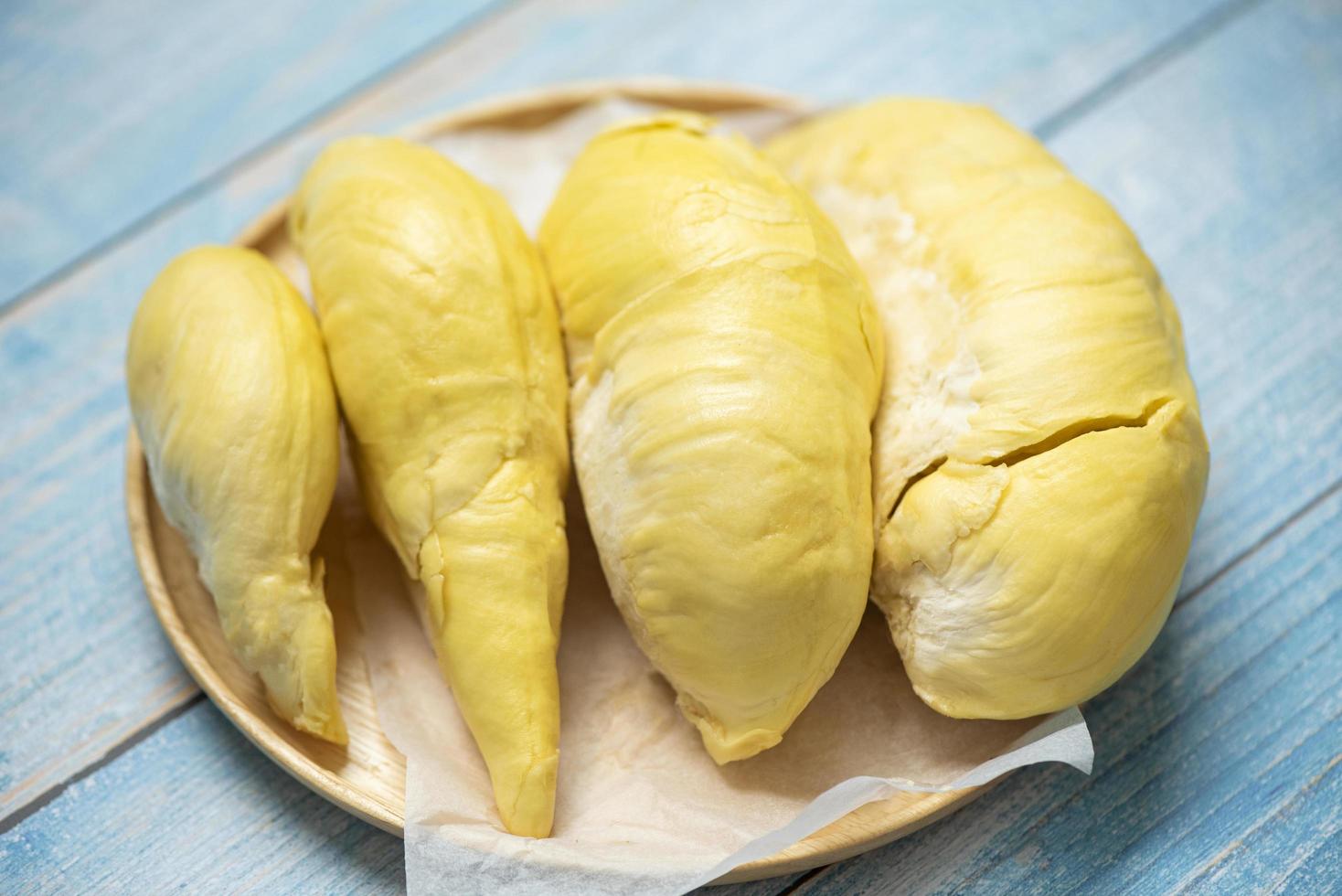 Durian fruit fresh from tree peel on wooden plate - Ripe durian tropical fruit summer for sweet dessert or snack in Thailand photo