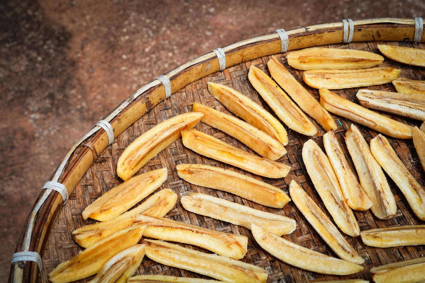 Dried banana background Organic banana long slice dry on bamboo threshing basket for sun drying photo