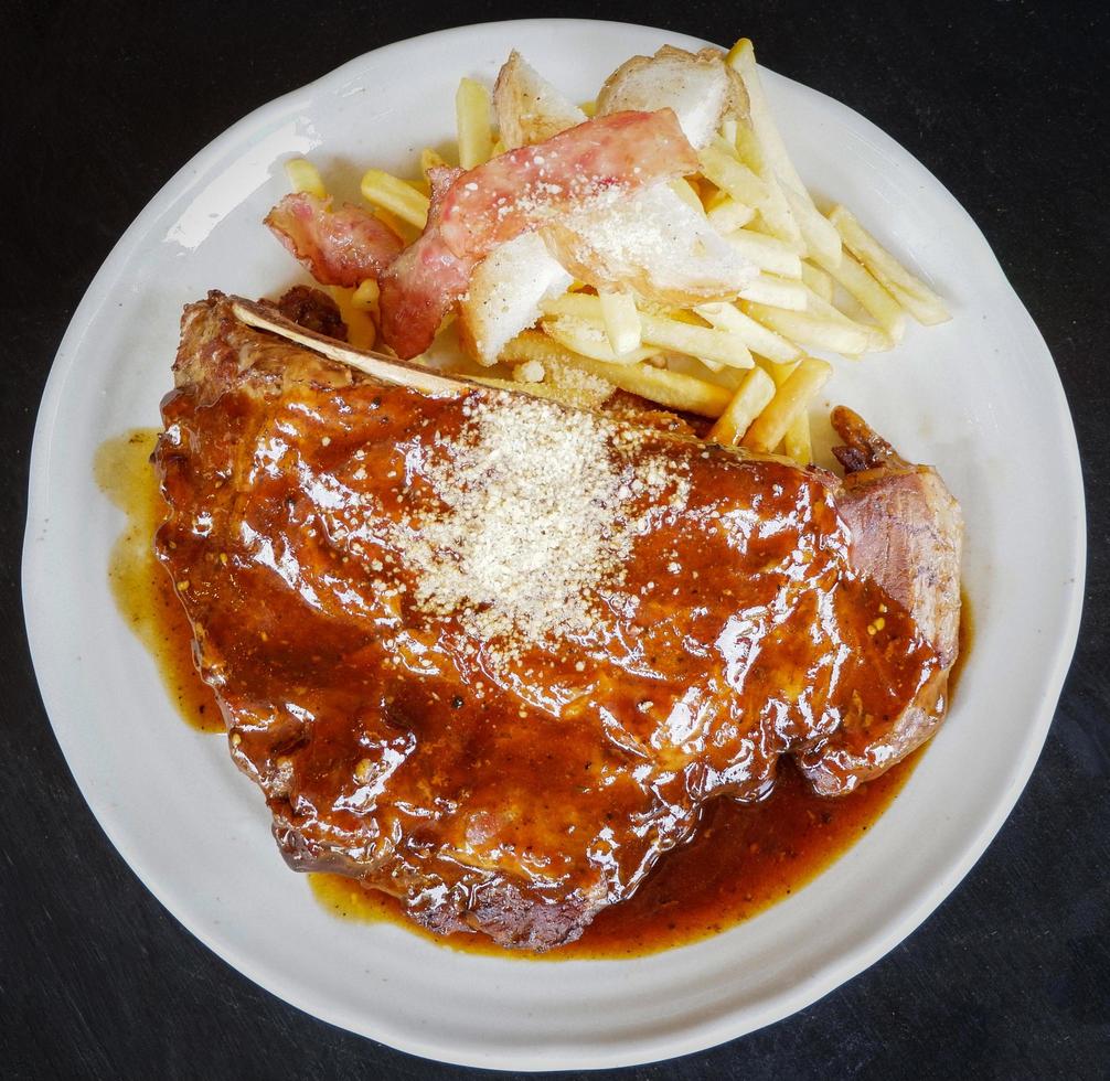 pork rib steak serve on plate barbecue pork roast french fries bacon and spicy sauce photo