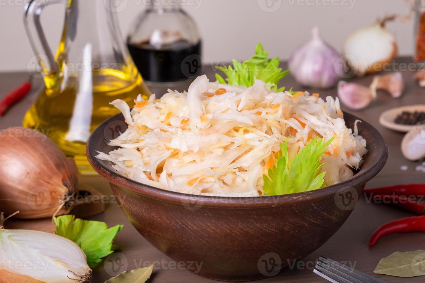 repollo fermentado con chucrut en un tazón de chucrut de cerámica sobre la mesa foto