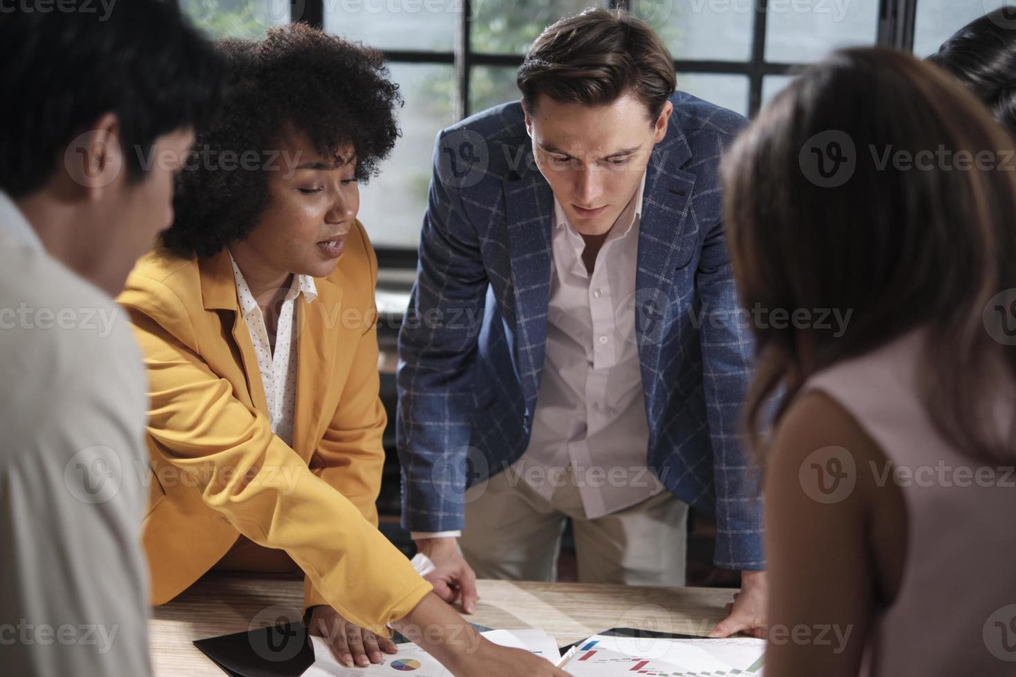 Multiracial coworkers' team and colleagues brainstormed, discussing marketing strategy, ideas collaboration, and business project planning at an office's conference table in staff meeting workplace. photo