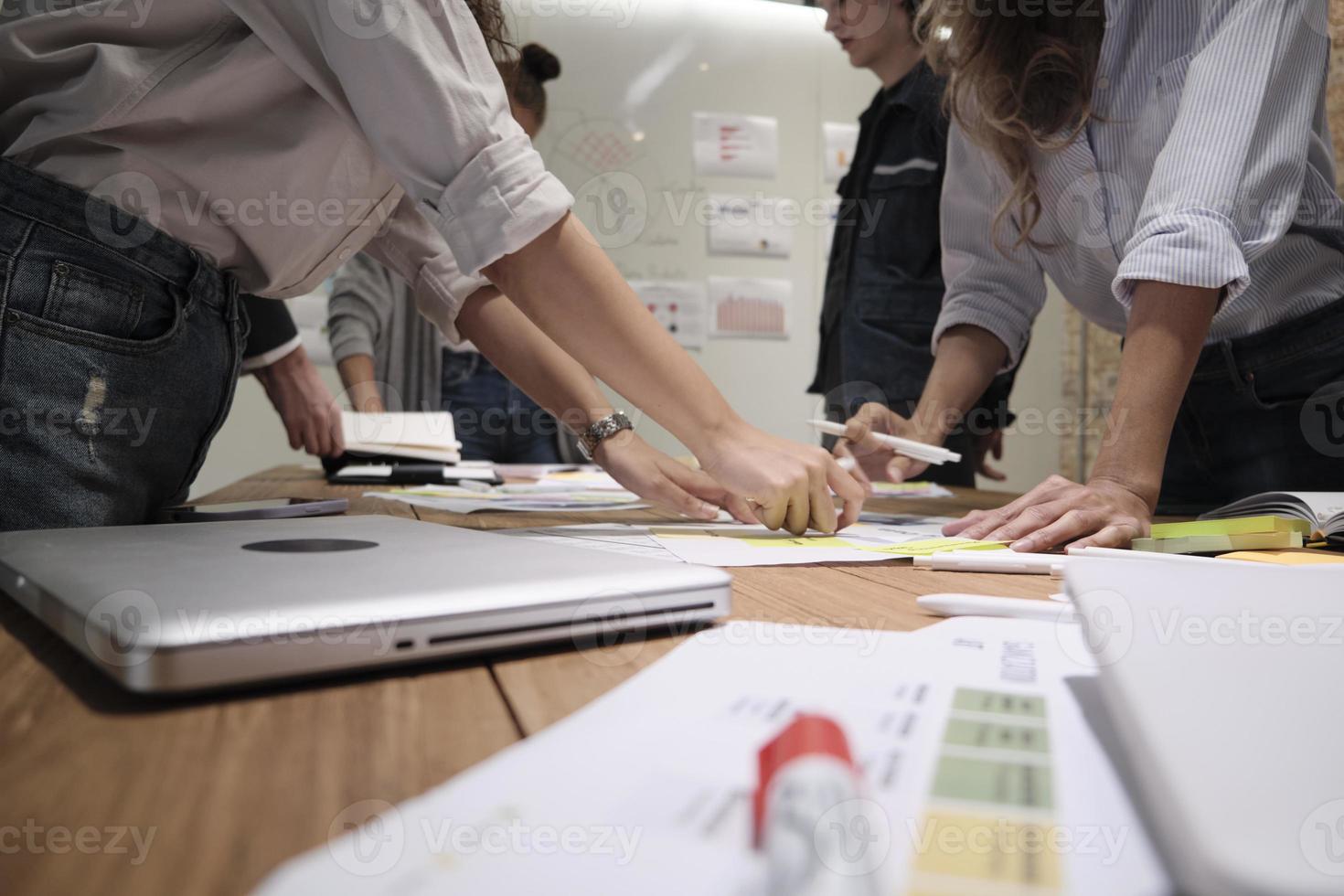 The coworkers' team and colleague brainstormed, discussing a marketing strategy, ideas collaboration, and business project planning at an office's conference table in the staff meeting workplace. photo