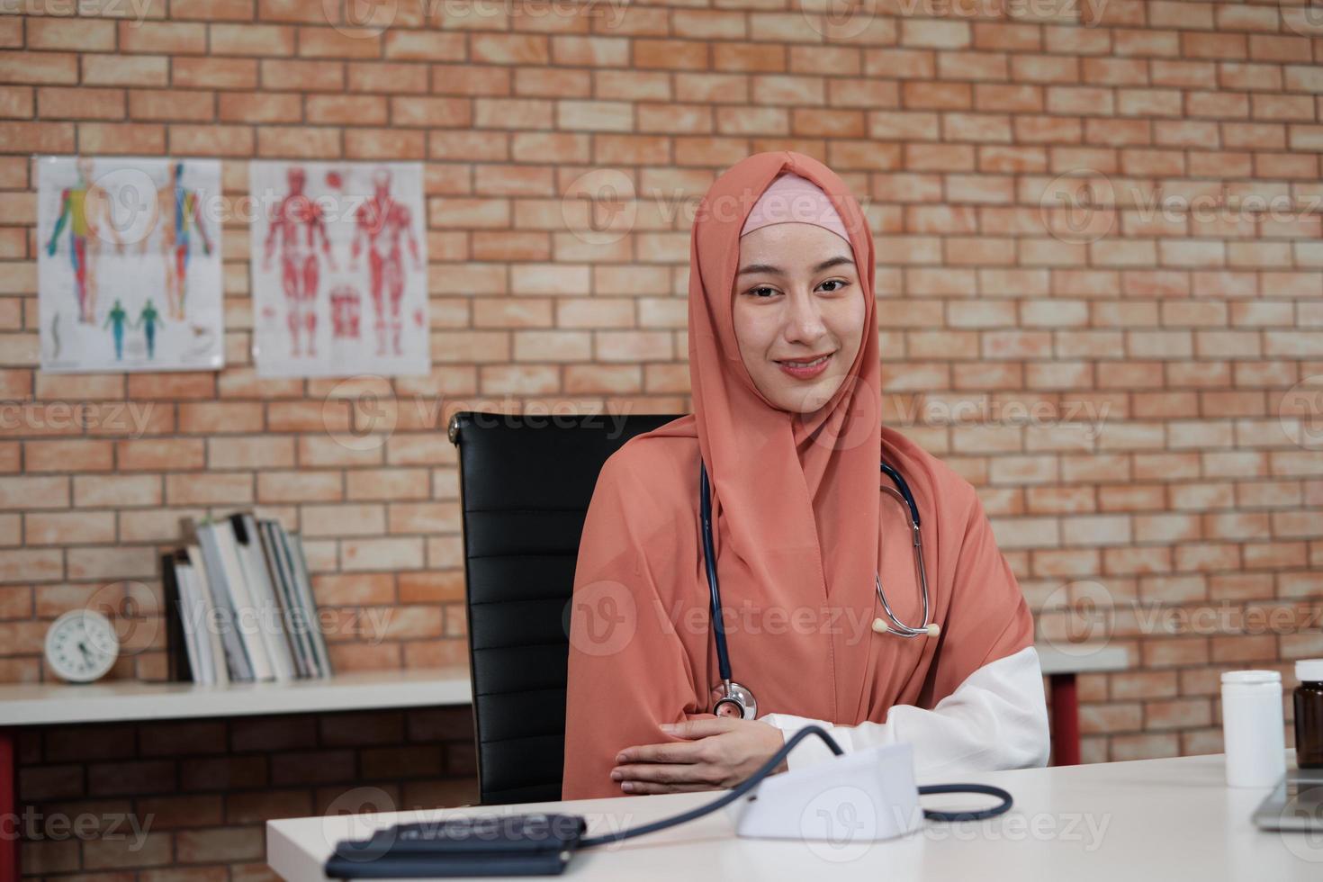 retrato de una hermosa doctora, hermosa musulmana en uniforme con un estetoscopio, sonriendo y mirando la cámara en la clínica del hospital. una persona que tenga experiencia en el tratamiento profesional. foto