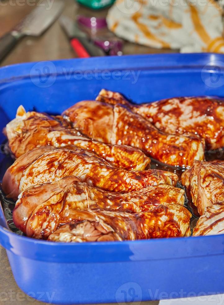 Marinated chicken legs with soy sauce in special bowl photo