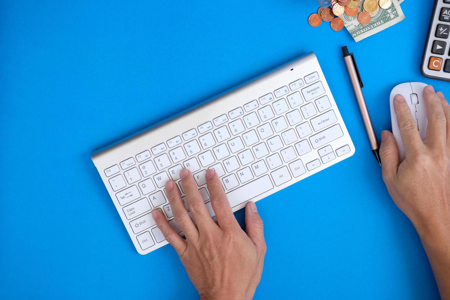 encima de la mesa del escritorio de la oficina con computadora portátil y suministros hay un pequeño cuaderno en blanco con bolígrafo. endecha plana, vista superior con espacio de copia. foto