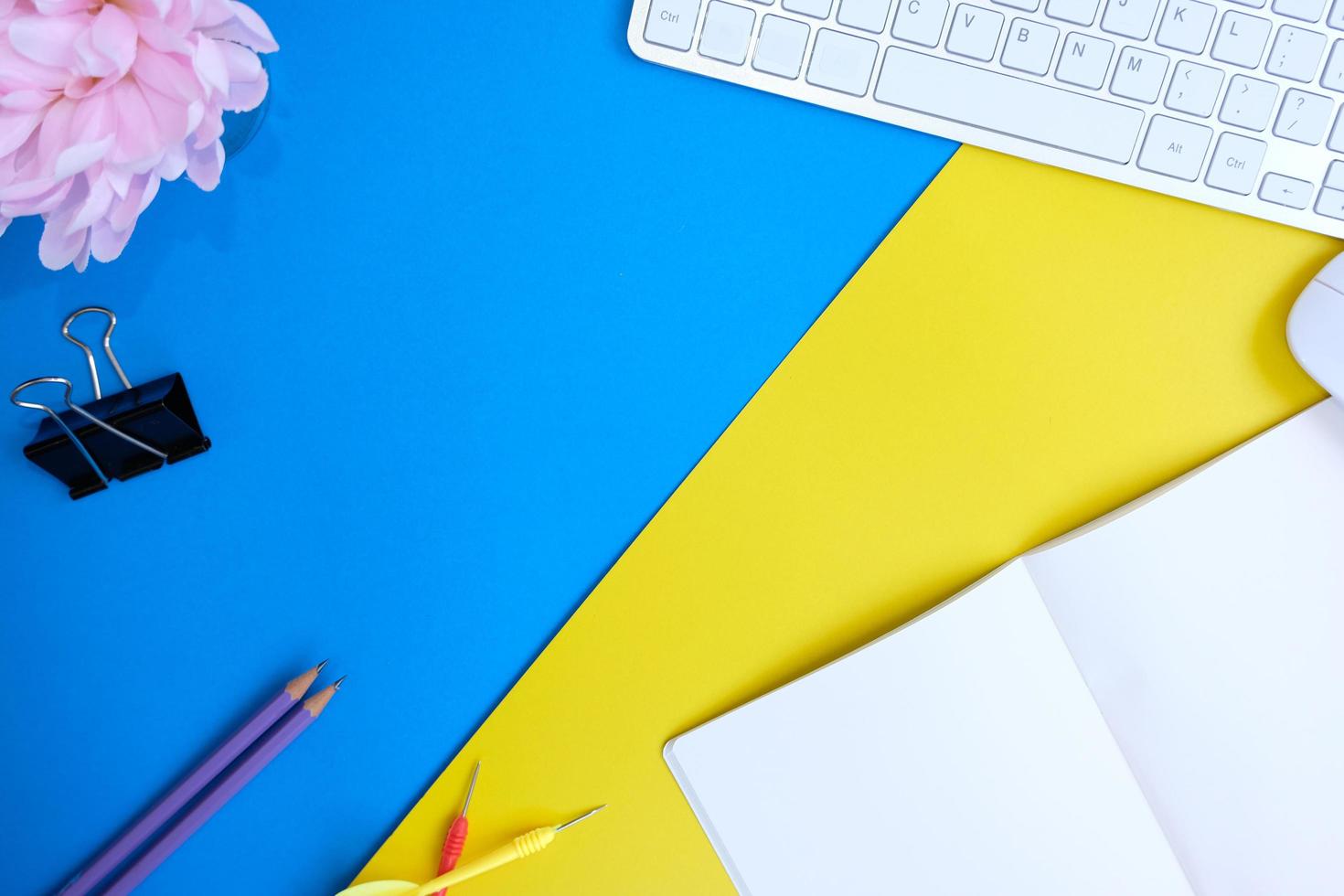 Blank notebook, a pencil, and space are on top of a blue office desk table. Flat lay, top view education concept photo