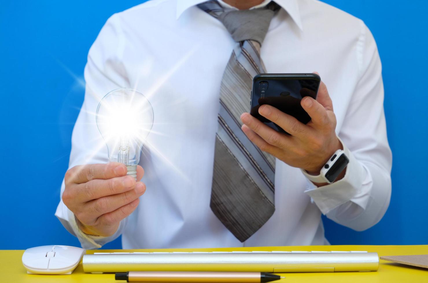 Businessman using his smartphone to send a text message photo