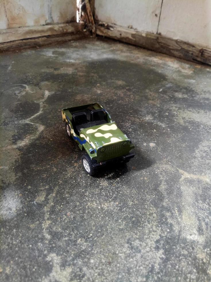 coche jeep verde en miniatura sobre fondo de pared de madera sucia foto