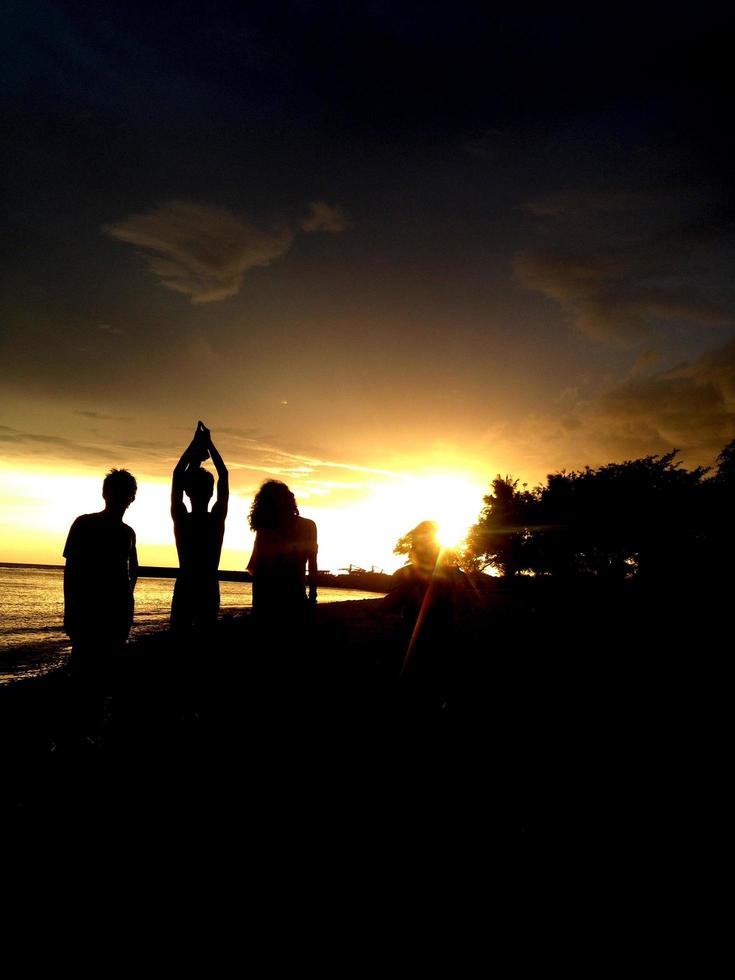 silueta de un grupo de jóvenes jugando en la playa foto