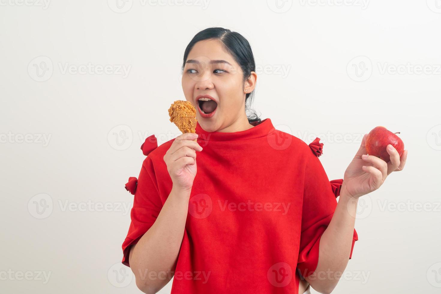 Asian woman with fried chicken and apple on hand photo