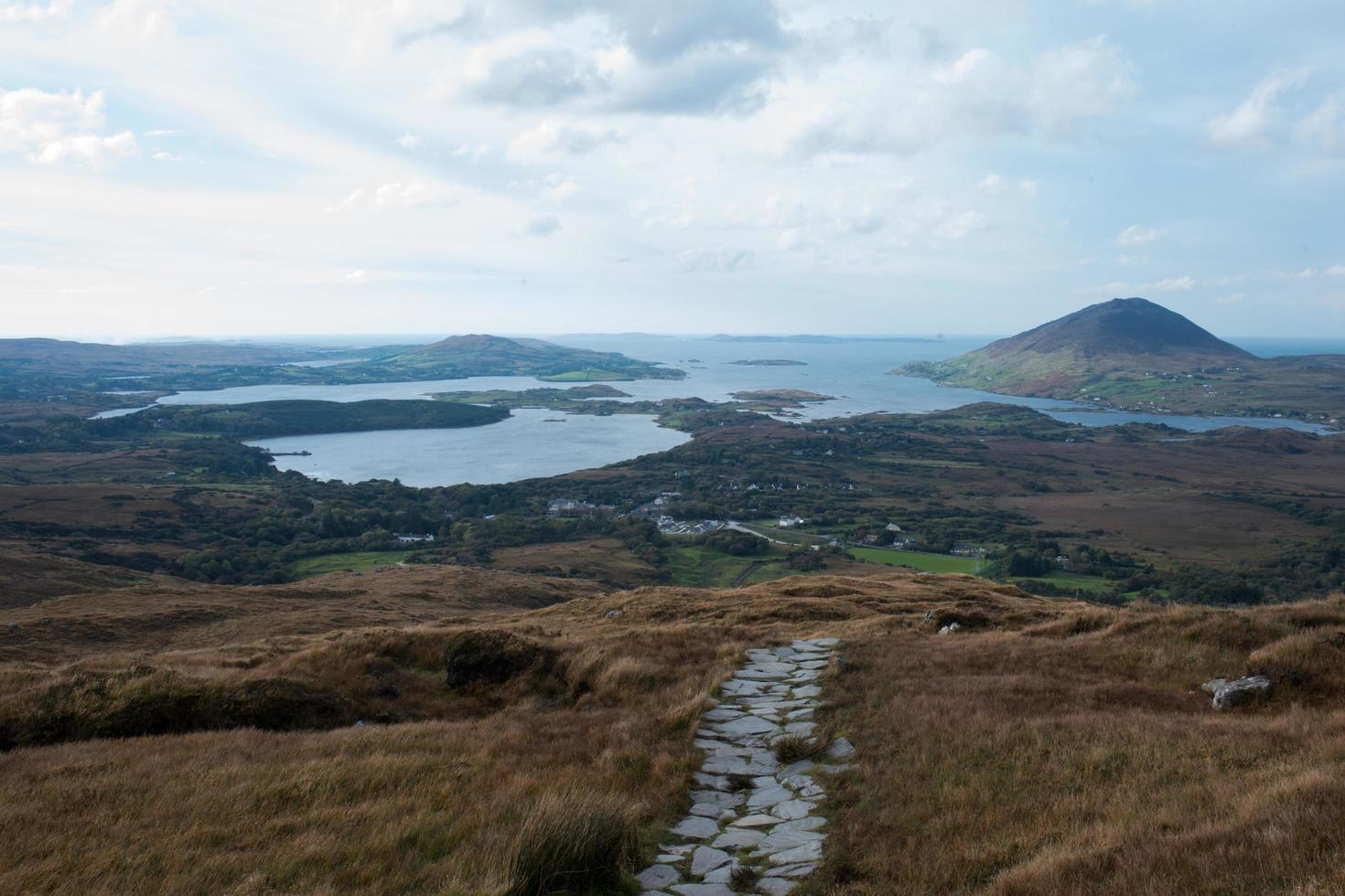 Beautiful irish landscape on a cloudy day.Hills,  lakes and a path made of stone. photo