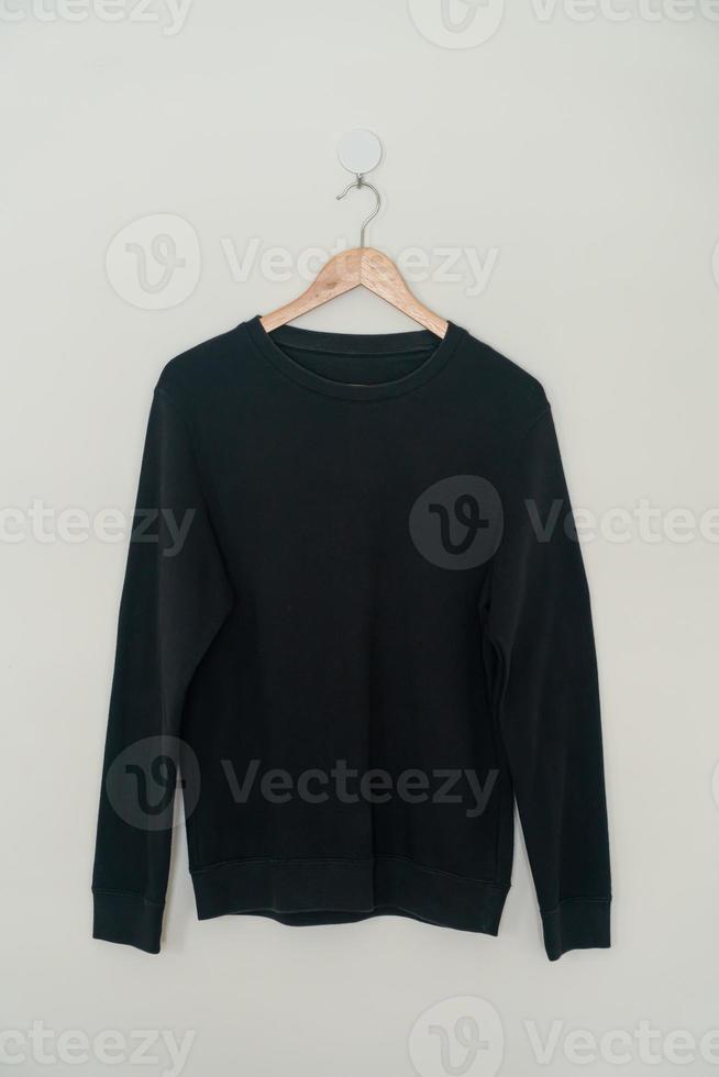 black sweater hanging on hanger photo