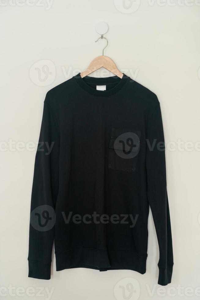 black sweater hanging on hanger photo