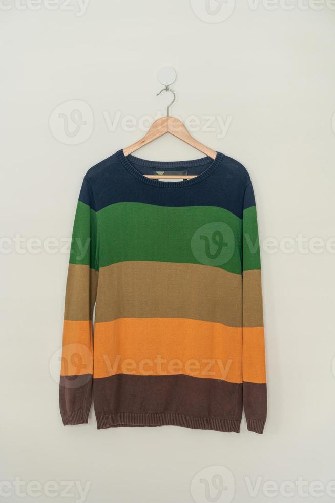 colorful sweater hanging with wood hanger photo