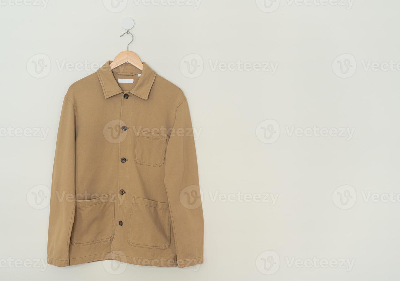 beige suit hanging with wood hanger photo