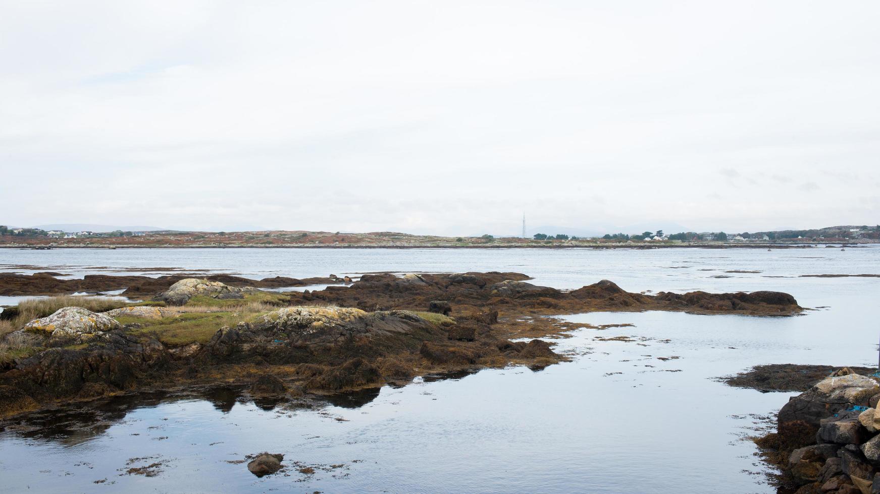 bonitos pueblos a lo largo de la costa irlandesa. rocas y mar durante la marea baja. Irlanda foto