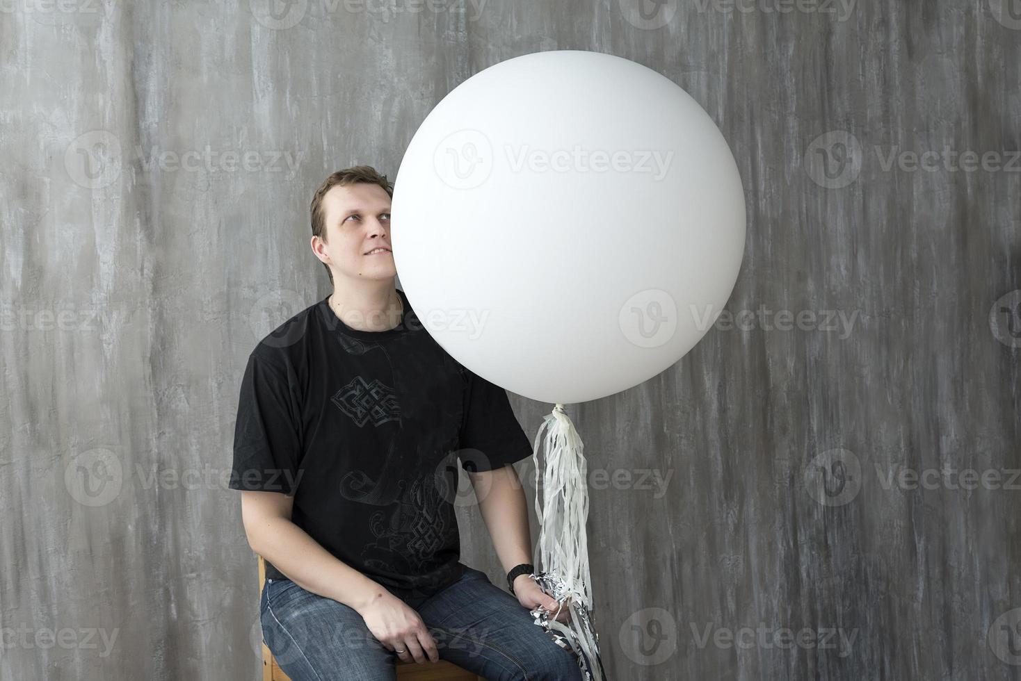 A man holding an inflatable ball on a gray background. photo