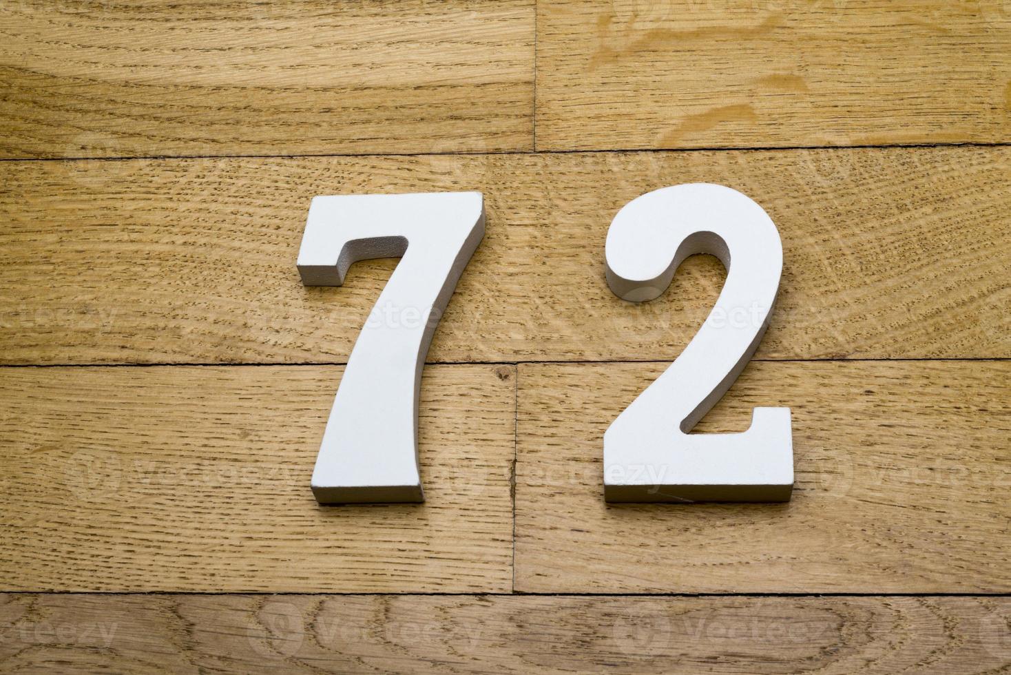 los números setenta y dos en el piso de parquet de madera. foto