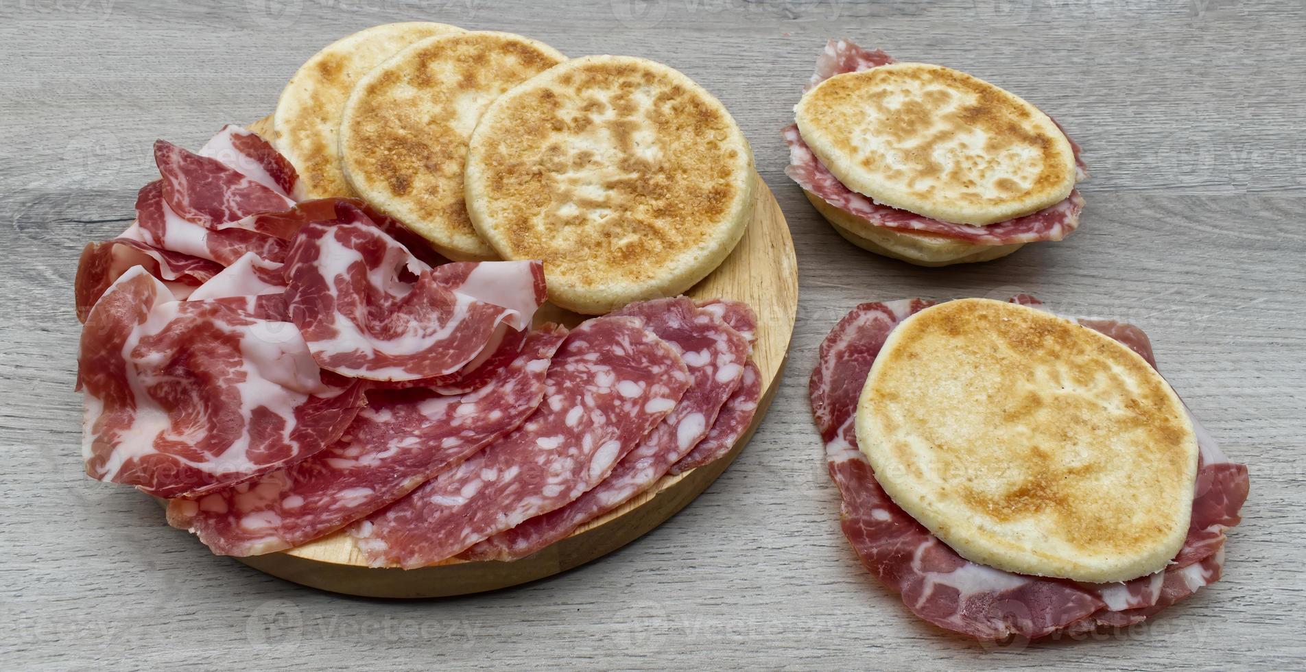 Delicious Italian Tigelle on wooden background. Traditional dish from Emilia-Romagna region. Bologna, Italy photo