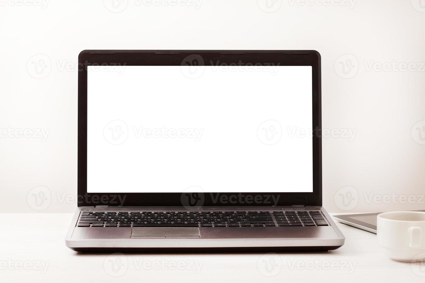 Laptop with blank screen on workplace. Empty space desk white office Interior. Copy space. Business concept. photo