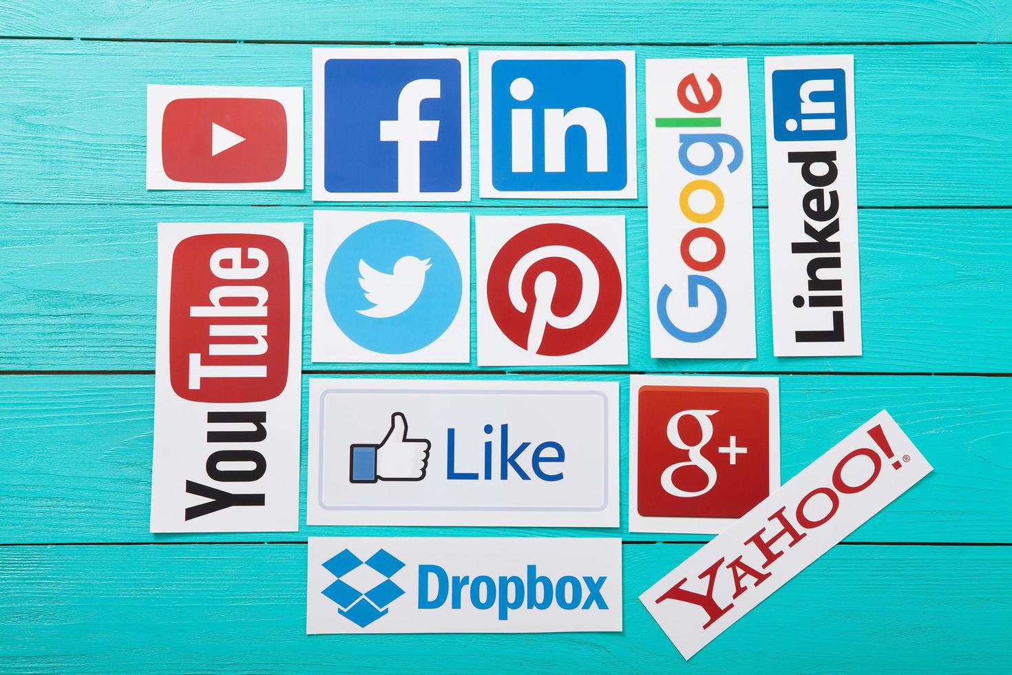 KIEV, UKRAINE - MARCH 10, 2017. Collection of popular social media logos printed on paper YouTube,Facebook, Twitter, Google Plus, Yahoo, Linkedin, Snapchat, Chrome and like on blue wooden background. photo