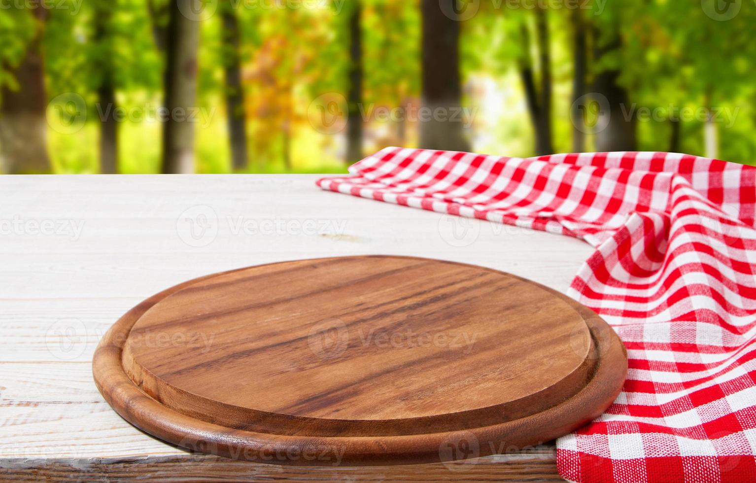 empty board and crumpled tablecloth on table against a blurred background of the park photo
