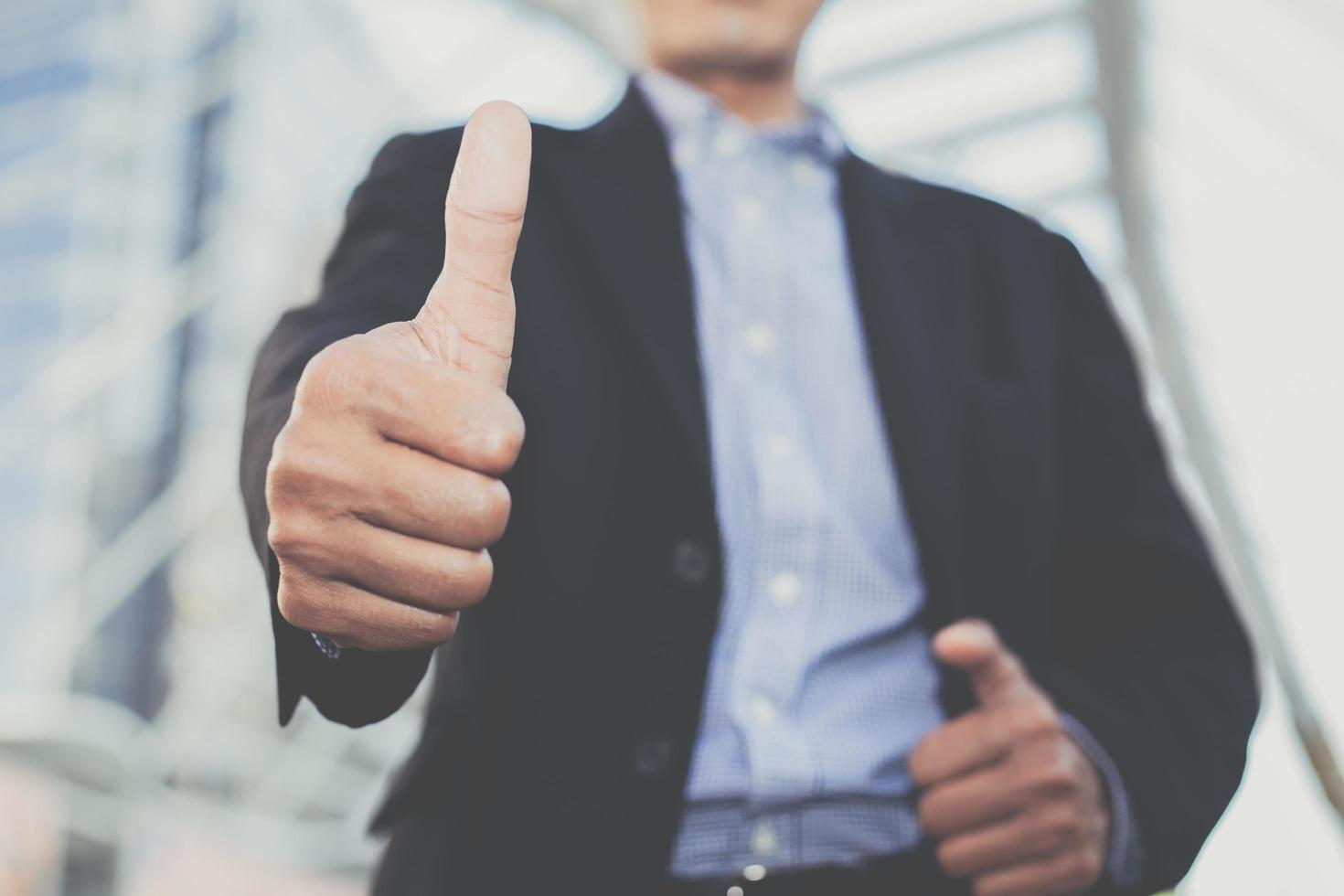 Businessman showing thumbs up - close-up shot photo
