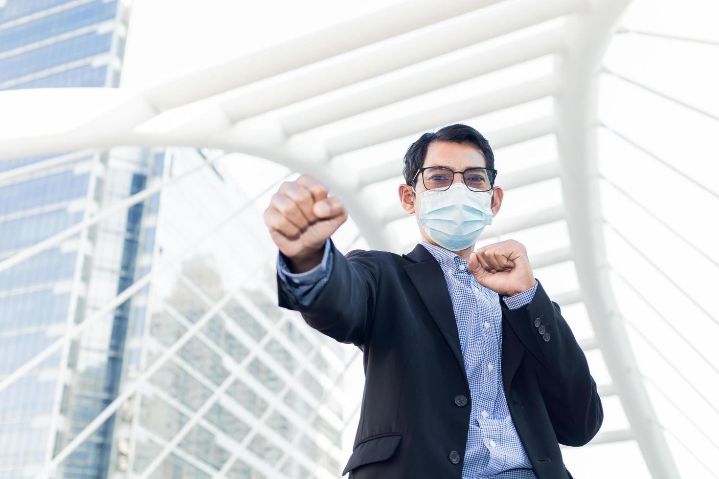 A businessman in a suit raises his fist while standing. photo