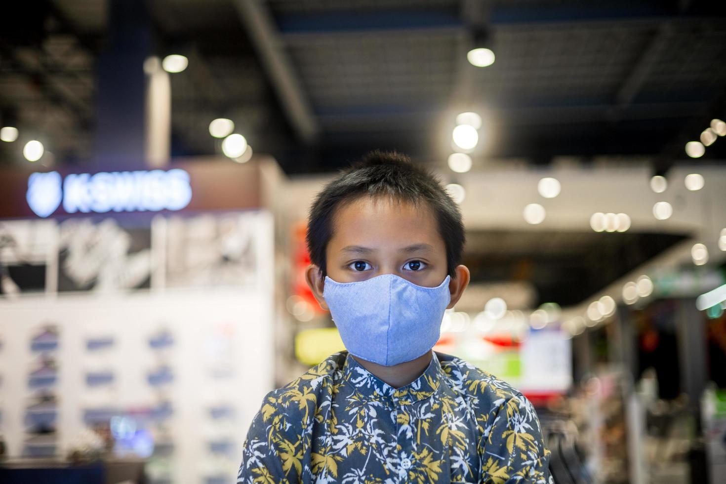 Asian boy wearing a mask in a shopping mall photo