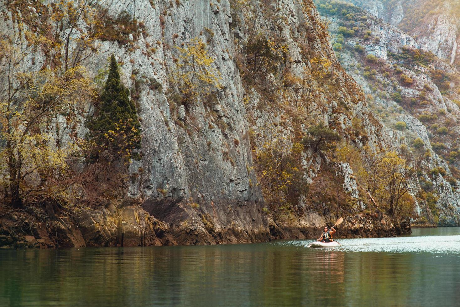 los turistas hacen rafting a lo largo del río de montaña en kayaks foto