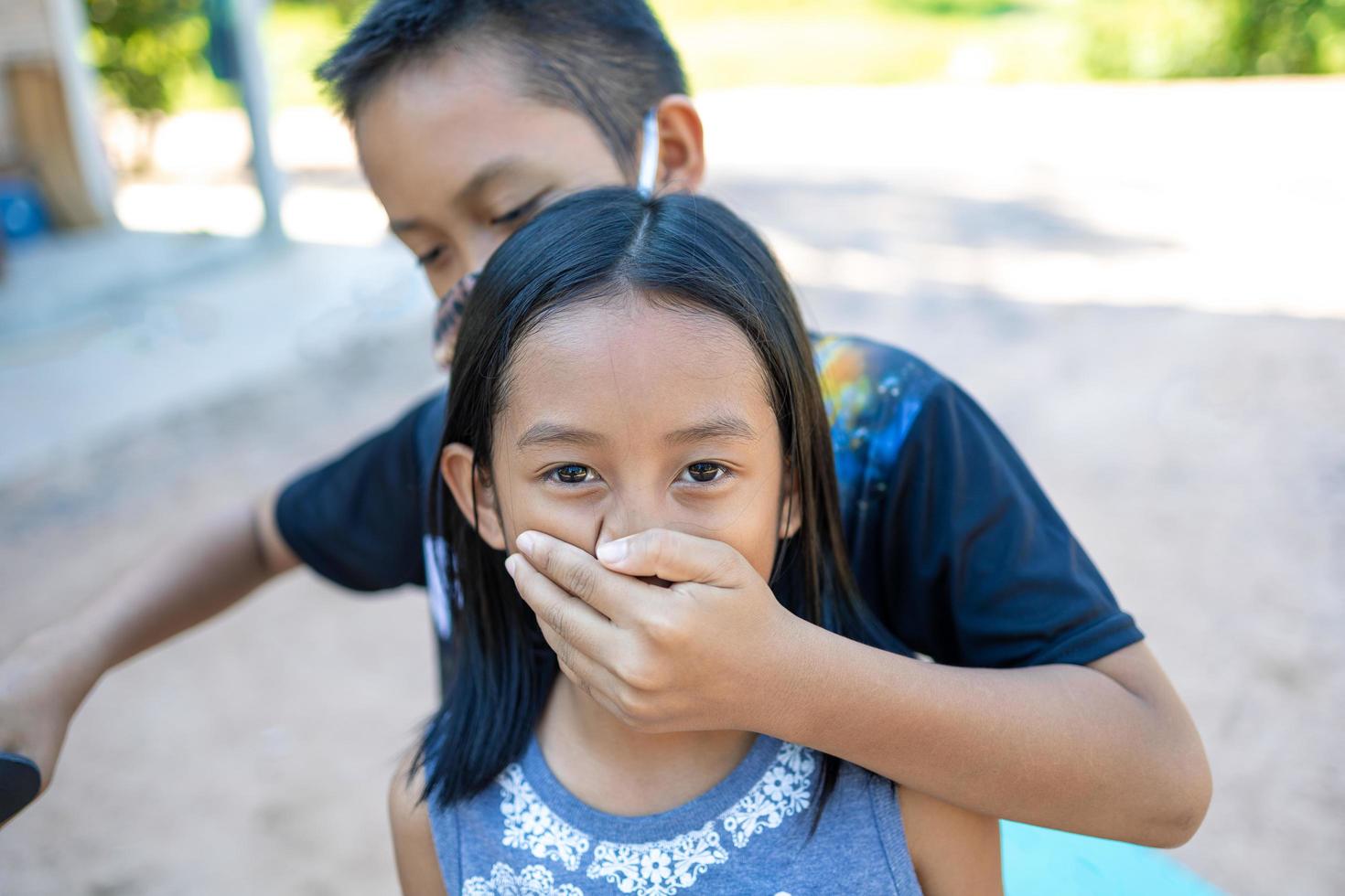 A boy and a girl play a hostage attacker. photo