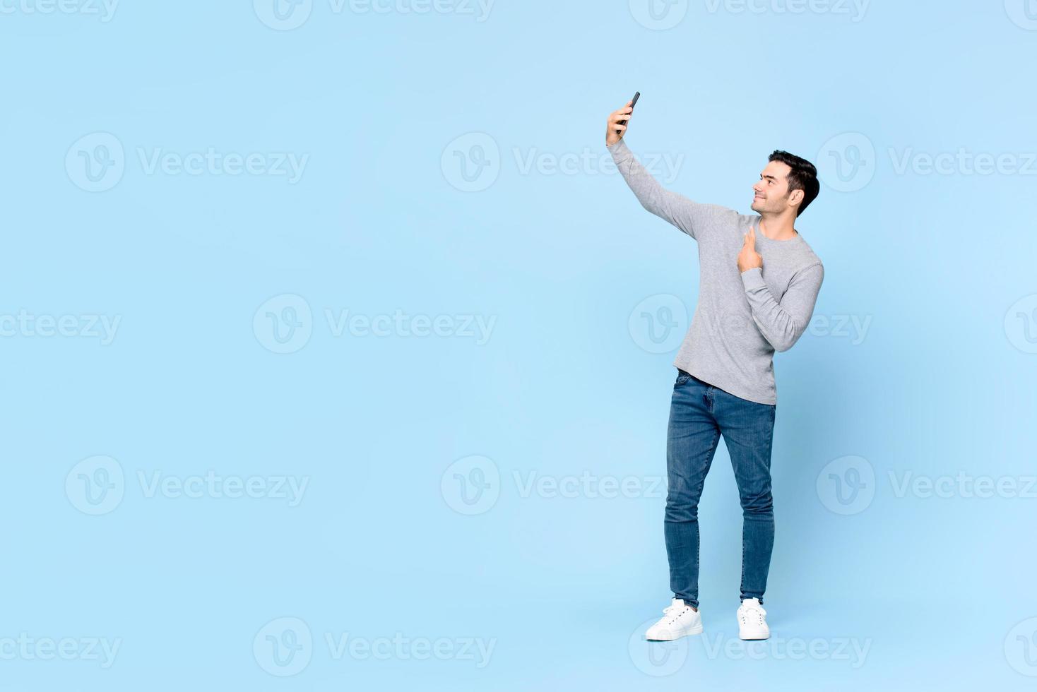 Full body portrait of young handsome man taking selfie on mobile phone  isolated on light blue background with copy space 5206162 Stock Photo at  Vecteezy