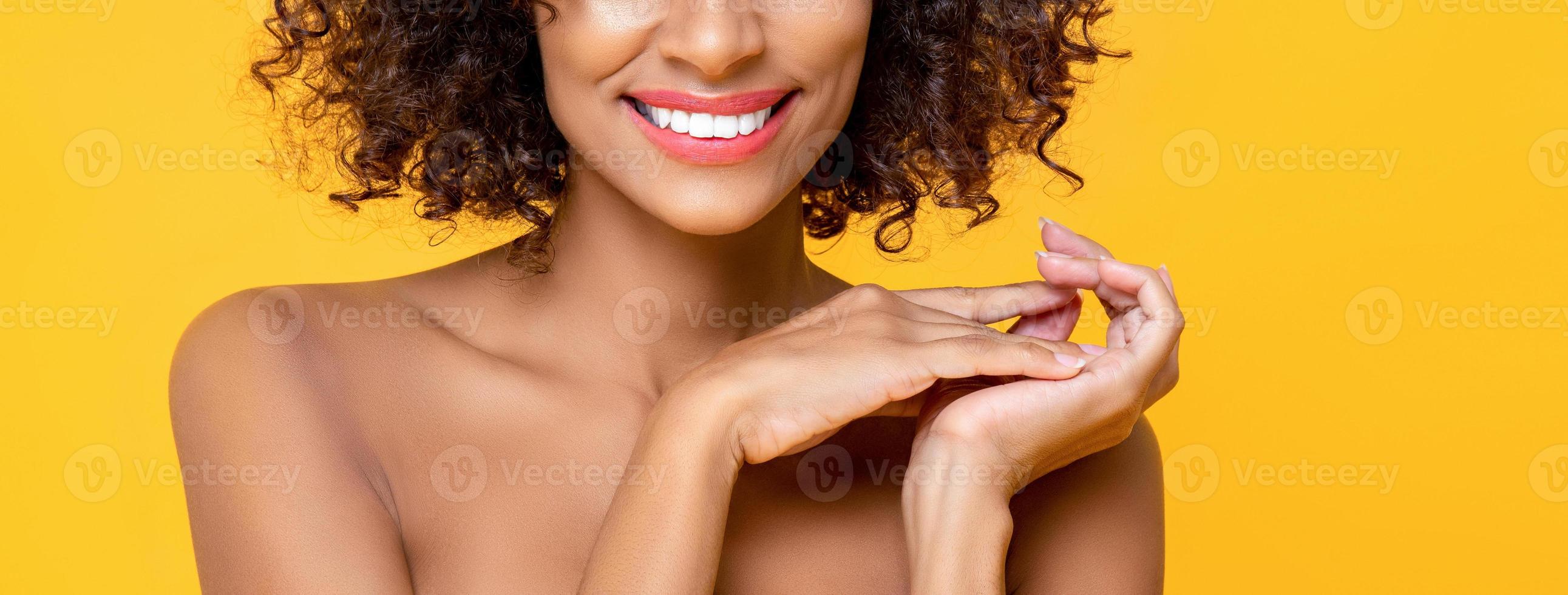 Half faced close up beauty portrait of smiling African American woman in hand touching palm gesture  isolated on yellow banner background photo