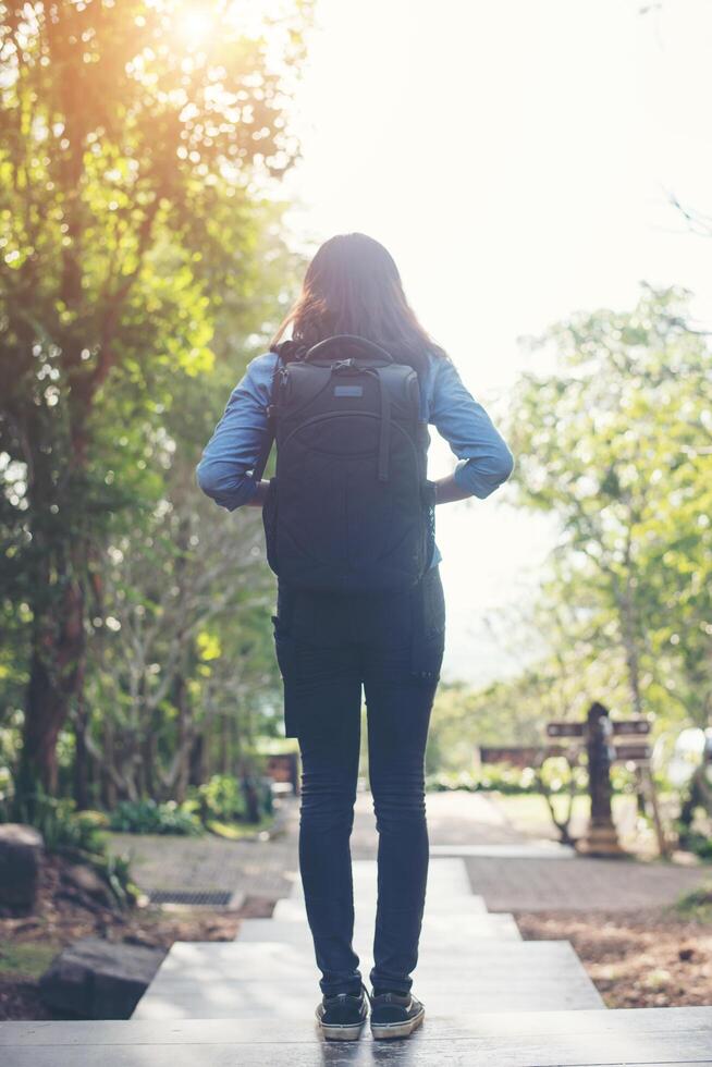 Freedom traveler hipster woman standing with raised arms and enjoying a beautiful nature. Achieved with adventure. photo