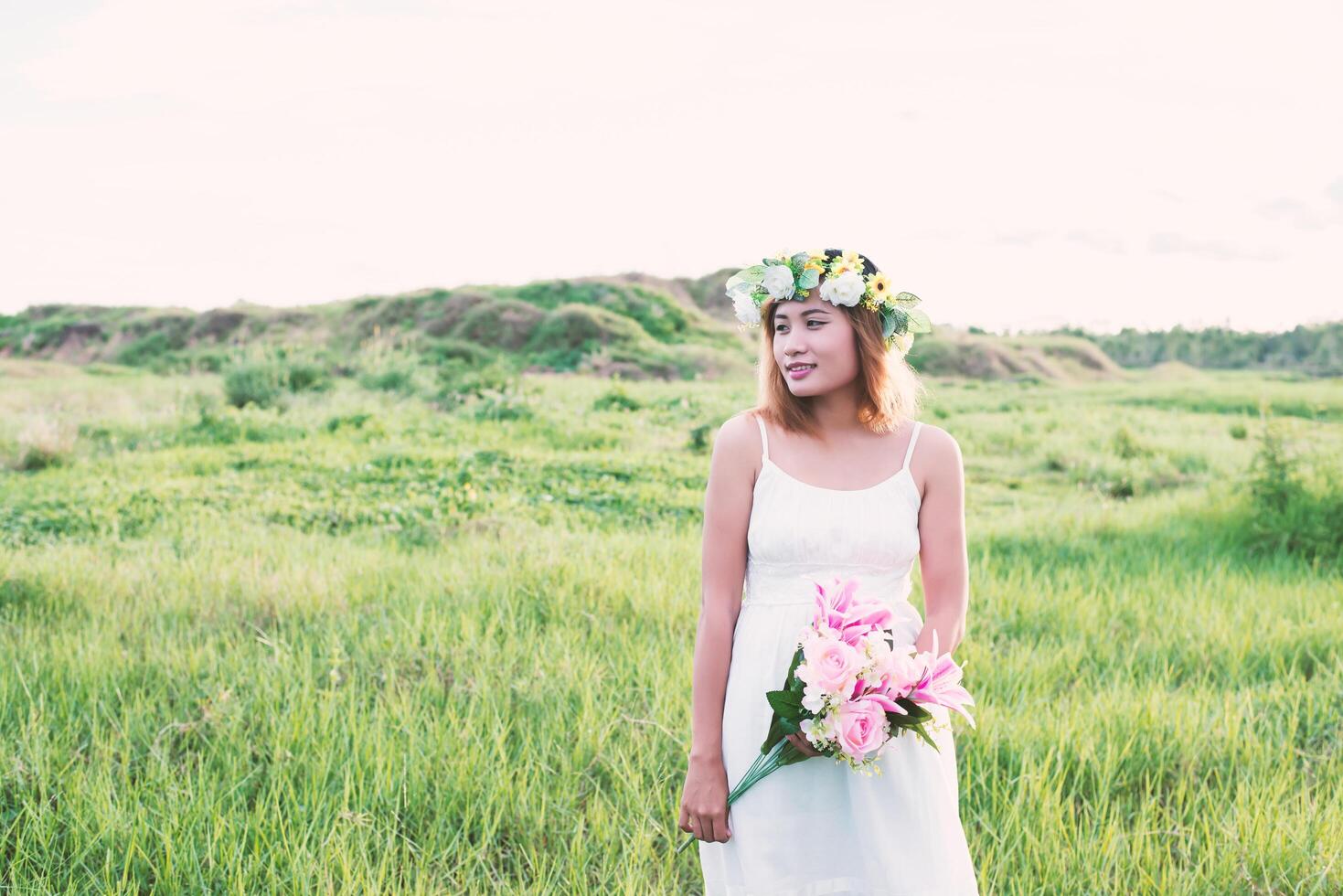 young beautiful woman holding flower on her hands and smiley. photo