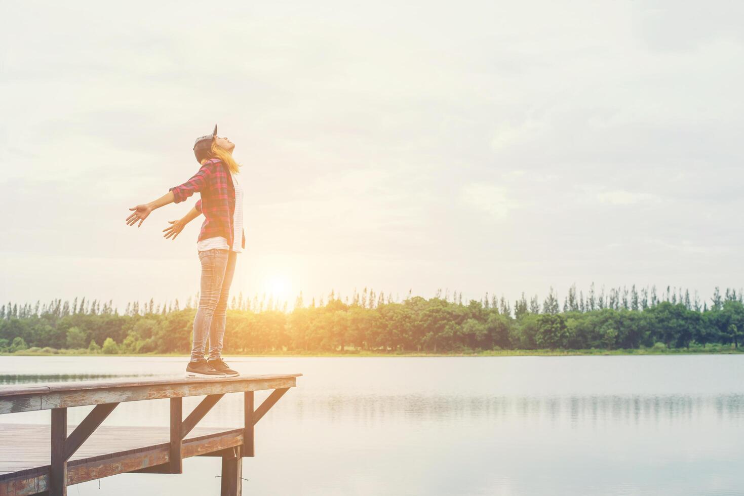 Happy hipster woman enjoying leisure at the pier lake,relaxing enjoy with natural. photo