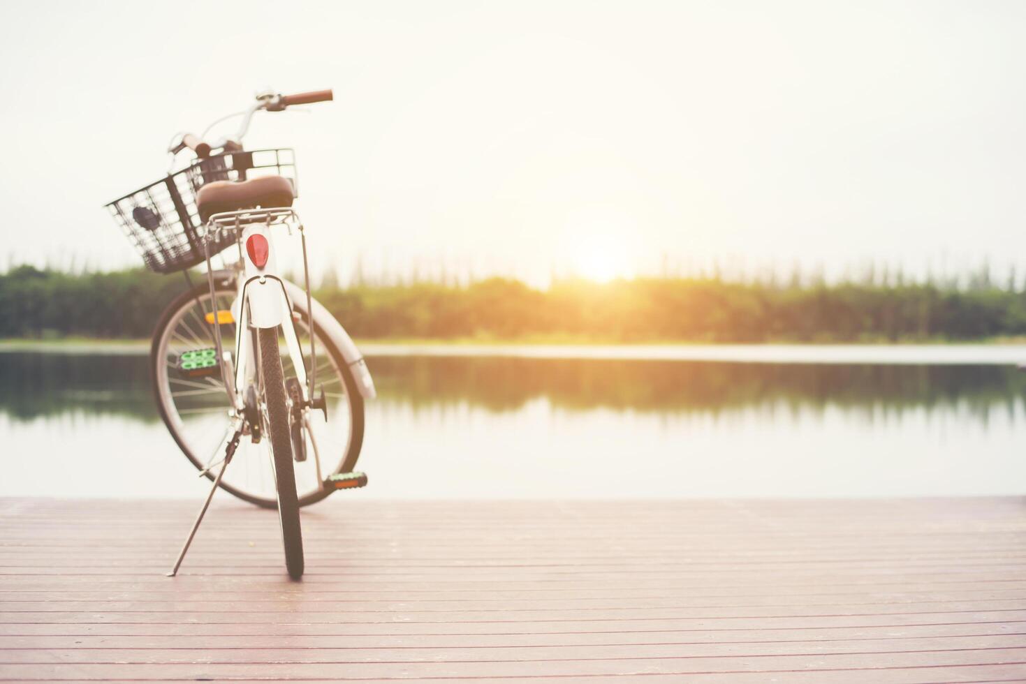 Vintage toned of bicycle with basket on empty pier, summer day. photo