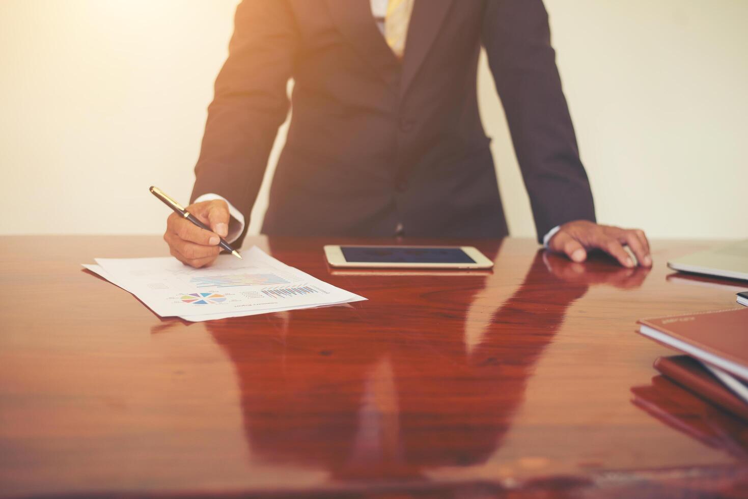 Woman's hand with a pen writing on the business paper. Report chart,busy at work. photo