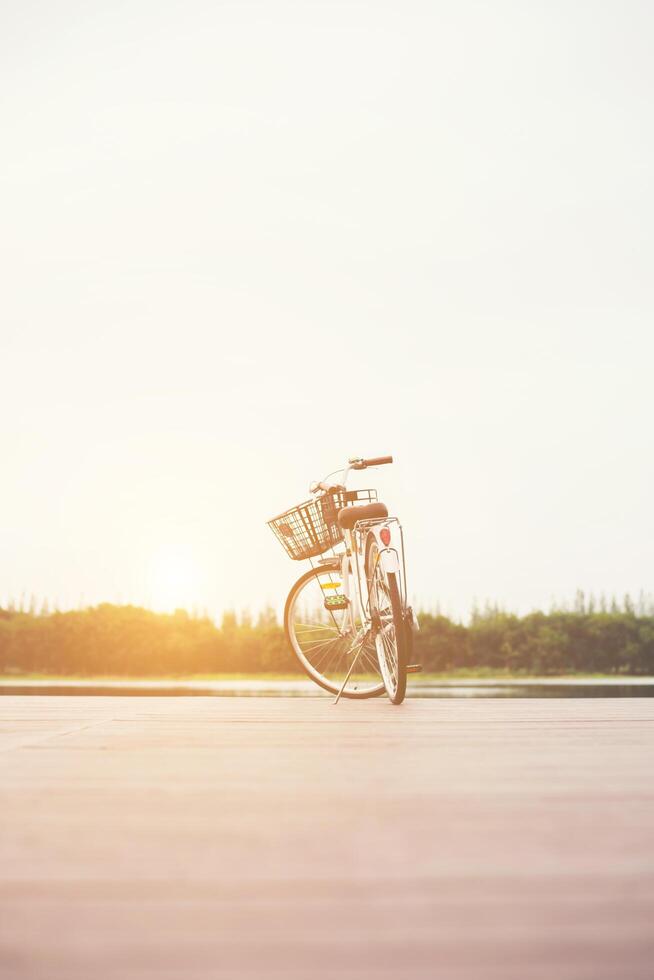 Vintage toned of bicycle with basket on empty pier, summer day. photo