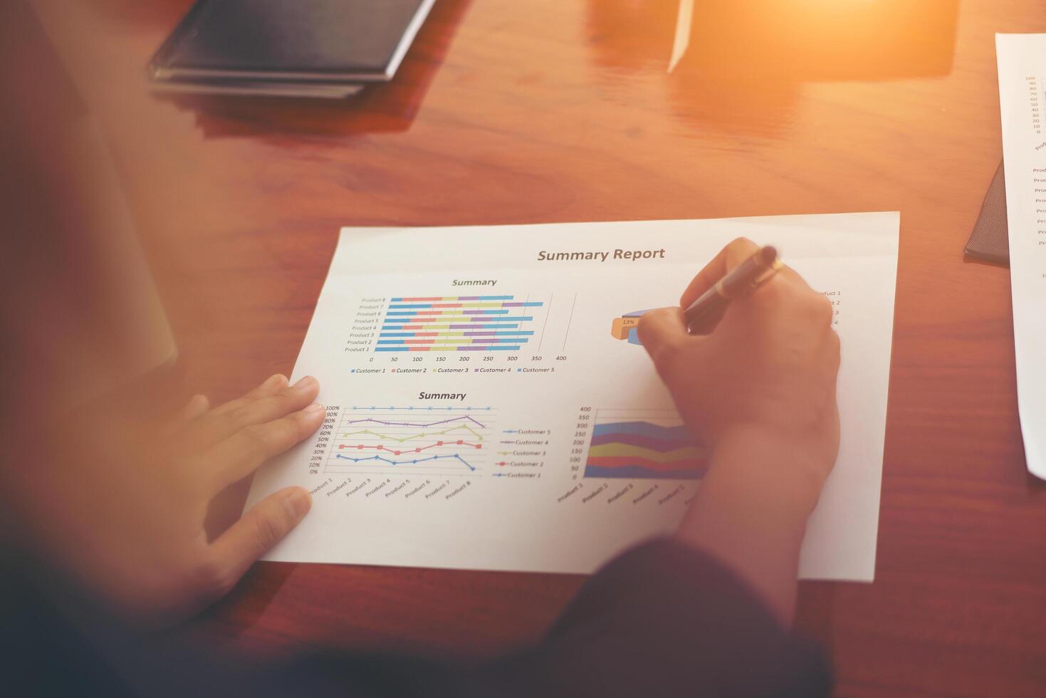 Woman's hand with a pen writing on the business paper. Report chart,busy at work. photo