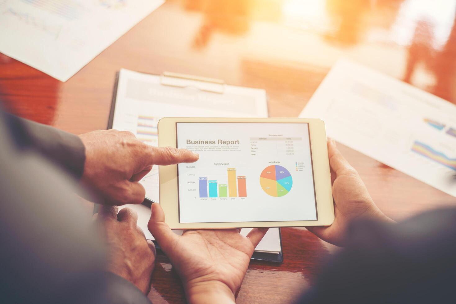 Graphs and charts being demonstrated on the screen of a touch-pad,time to meeting with team business. photo