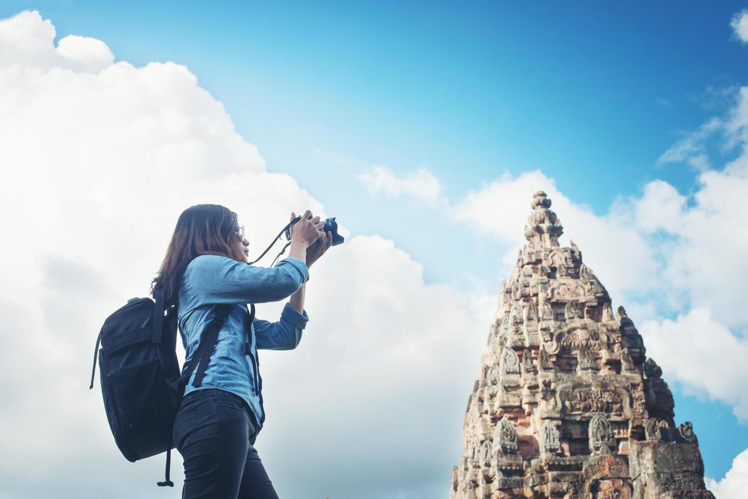 joven y atractiva mujer fotógrafa turista con mochila que viene a tomar fotos en el antiguo templo de peldaño fantasma en tailandia.